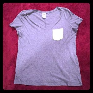 a grey short sleeved shirt with a green pocket.